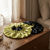 Chartreuse and black silk bonnet placed on wooden dresser in bedroom lifestyle setting
