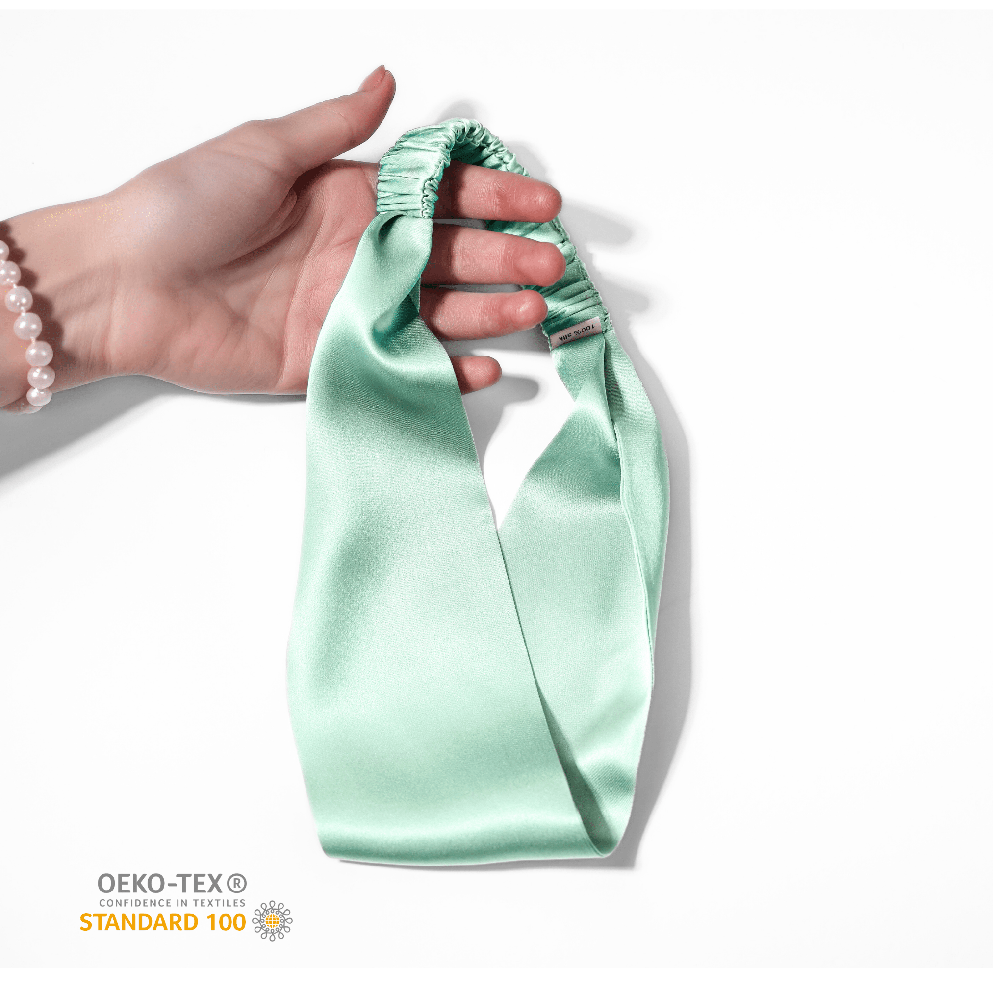 OEKO-TEX certified Aqua Blue 100% Mulberry Silk Headband held in hand – safe for skin and eco-friendly
