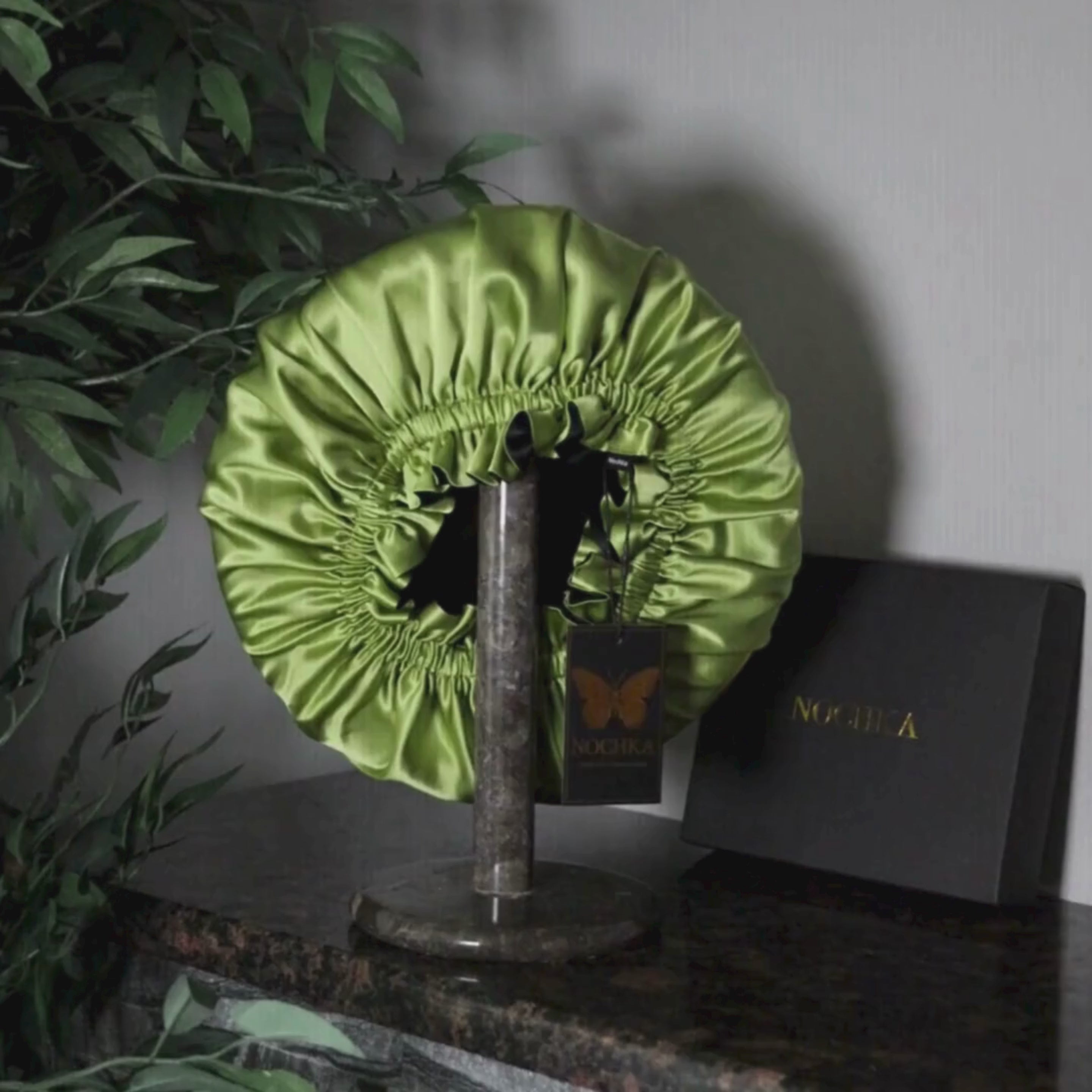 Top view of chartreuse and black reversible mulberry silk bonnet showing gathered elastic opening
